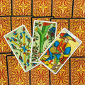Tarot kortos Marseille stiliaus, ryškios priekinės kortos (Karalius monetų, lazdos, stiebas) ant raudono ornamentuoto nugarėlių fono