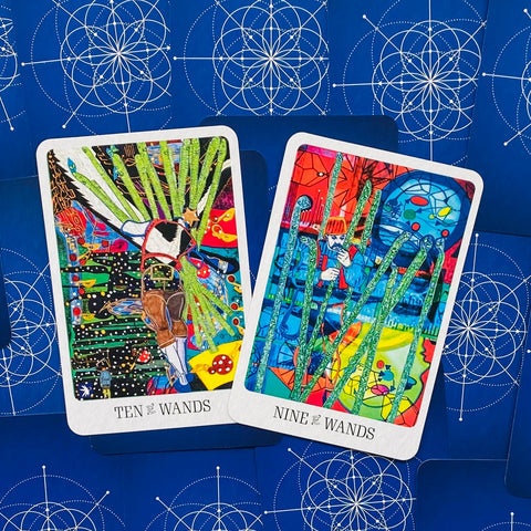 Tarot kortos su ryškiomis meninėmis Ten of Wands ir Nine of Wands kortomis ant mėlyno geometrinio fono, persidengiančios kampu