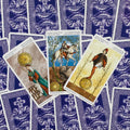 Tarot kortos — trys Pentaklių kortos (Karalienė, Riteris, Pusbrolis) išklotos ant violetinių nugarėlių