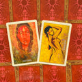 tarot kortos – dvi atverstos kortos (Past Lives raudonas portretas, Surrender geltona figūra) ant raudonų ornamentuotų nugarėlių