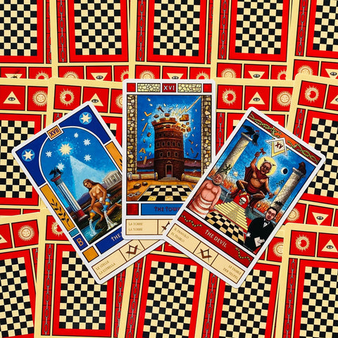 tarot kortos, atverstos trys kortos (Žvaigždė, Bokštas, Velnio) ant raudono‑juodo šachmatinio nugarėlės fono