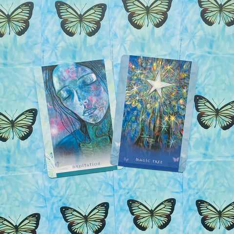 Orakulo kortos su „Meditation“ ir „Magic Tree“ dizainais, mėlynos tonacijos kortų priekis ant drugelių fono