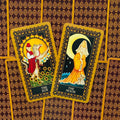Tarot kortos su aukso rėmeliais, rodančios The Sun ir The Moon kortas ant raštuoto bordo fono, skirtos aiškinimui