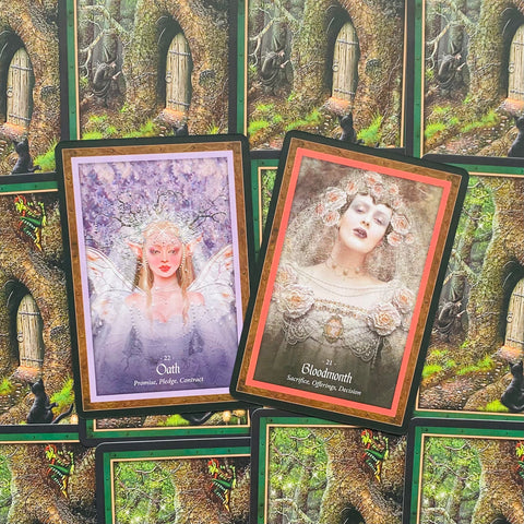 Tarot kortos — dvi iliustruotos orakulo kortos Oath (violetinė) ir Bloodmonth (rausvas rėmas) ant miško fono