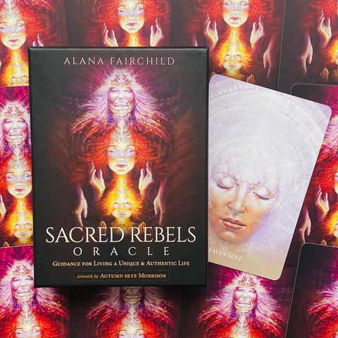 Orakulo kortos Sacred Rebels dėžutė su tamsiu viršeliu ir ryškia daugiasluoksne iliustracija, šone atversta korta „Heaven Sent“