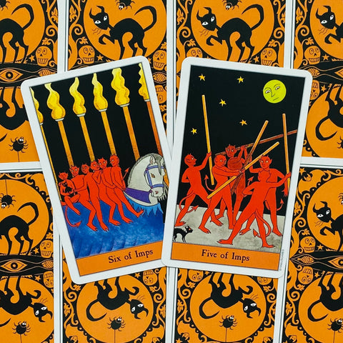 Tarot kortos Halloween leidimas: dvi kortos (Six of Imps ir Five of Imps) ant oranžinės–juodos nugarėlės, pasvirusiu kampu išdėstytos