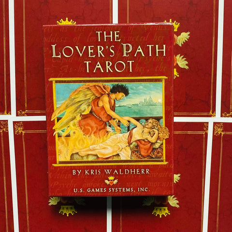 Prekės puslapis — raudonas The Lover's Path Tarot kortų dėklas, priekinis vaizdas su angelu ir gulinčia moterimi, autorius Kris Waldherr, centruotas ant raudono fono