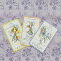 Orakulo kortos rinkinys — trys kortos (Energy, Empowerment, Dreams) su geltonu, oranžiniu ir violetiniu apvadu ant rausvo‑violetinio fono