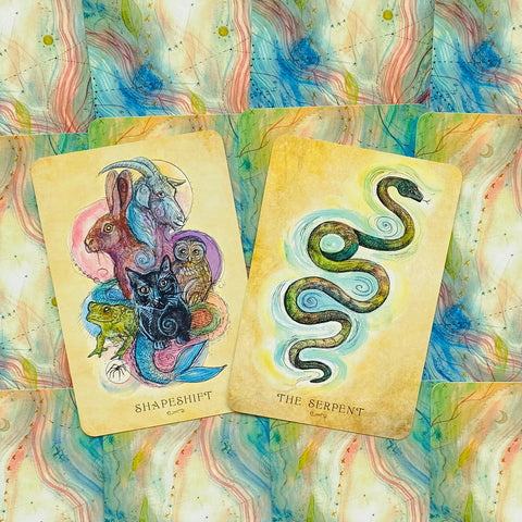 Tarot kortos dviejų kortų išklotinė (Shapeshift ir The Serpent) ant spalvoto akvarelės fono, rodoma iš viršaus