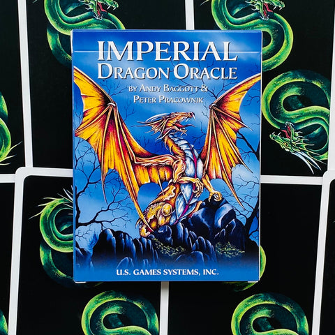 Orakulo kortos Imperial Dragon, mėlyna dėžutė su auksiniu drakonu, stovi priekinėje pozicijoje prieš fonines kortų nugarėles, pakuotės priekinis kampas