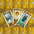 Tarot kortos Guido Crepax, aukso geltonos nugarėlės ir trijų atvirų kortų (tarp jų Monetų tūzas, Taurių karalius) priekinis dizainas