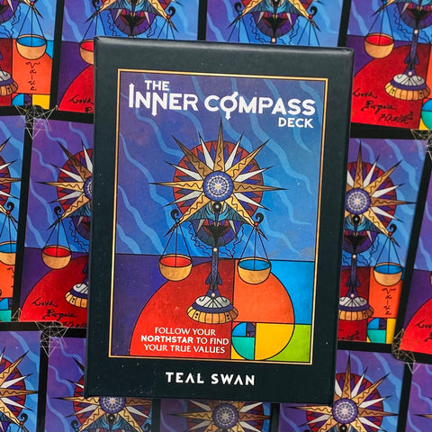 Inner Compass kortų rinkinys, Teal Swan dėžutė mėlynais ir raudonais tonais, priekinė pusė su stilizuotu kompasu ir svarstyklėmis