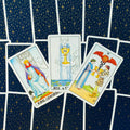 Tarot kortos Rider–Waite stiliumi, trijų kortų išklotinė: Karalius kardų, Puodelių tūzas ir Dviejų puodelių kortos ant tamsiai mėlynos žvaigždėtos nugarėlės