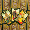 tarot kortos vintage žaliais kraštais, trijų kortų išdėstymas su išryškintu centre Merchant ir ornamentuotu kortų fone