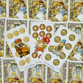 Tarot kortos su auksiniais pentakliais ir nykštukų iliustracijomis, fanuotos 8–10 pentaklių kortos rodo dizaino detales