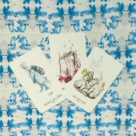 Tarot kortos – trys atvertos puodelių kortos (6, 7, 8) iš meninės mini kaladėlės, išdėstytos ant mėlynos akvarelinės nugarėlės
