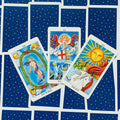 tarot kortos Rider‑Waite stiliaus, trys atverstos kortos (The World, Judgement, The Sun) ant mėlynų nugarėlių su auksinėmis žvaigždėmis