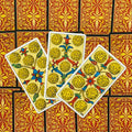 Tarot kortos — trys išskleistos monetų rūšies kortos su geltonais ornamentais ir raudonomis auksuotomis nugarėlėmis