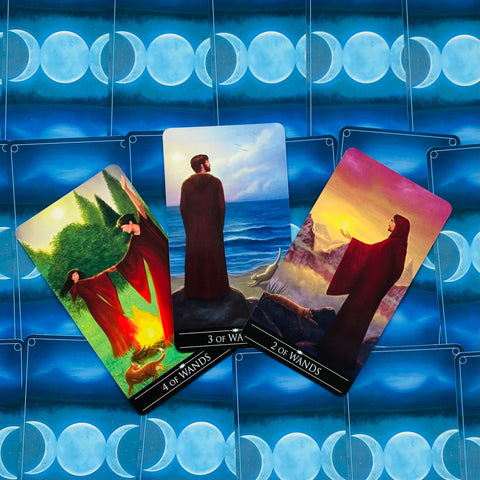Tarot kortos — trys iliustruotos 4, 3 ir 2 lazdų kortos ant mėlynos mėnulio nugarėlės, parodytos kaip komplekto pavyzdys