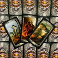 Tarot kortos su tamsiomis dekoruotomis nugarėlėmis, trys atverstos kortos kampu rodo fantazines figūras ir drakonus