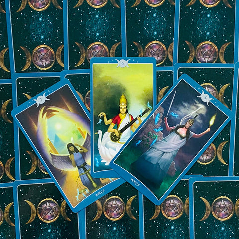 tarot kortos mėlynomis nugarėlėmis, trijų kortų išskleistas taro išklotas su ryškiomis, skirtingomis iliustracijomis