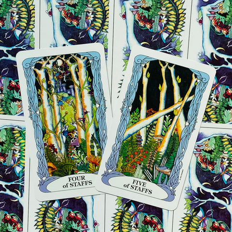 Tarot kortos — du atviri kaladės lapai (Four of Staffs ir Five of Staffs) ant spalvingo nugarėlių motyvo, artimas planas