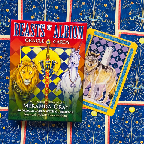 Beasts of Albion oracle kortos: Miranda Gray raudona dėžutė su liūtu ir viena atversta vilko korta, pabrėžtas gidukas ir 40 kortų rinkinys