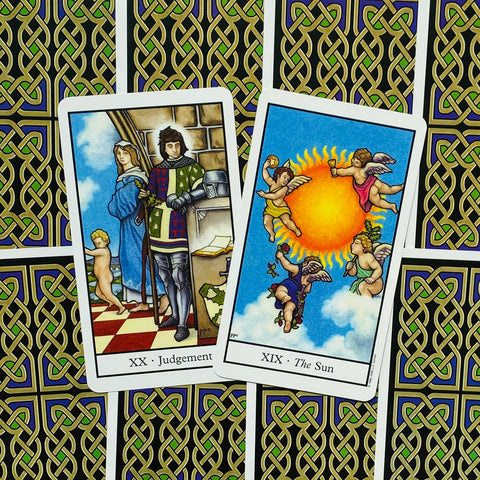 tarot kortos Rider–Waite: dvi atviros kortos (XX Teismas, XIX Saulė) ant žalio‑juodo keltų rašto nugarėlės