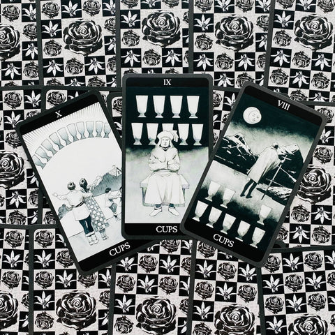 tarot kortos juodai baltos Cups komplektas: trys išdėstytos kortos (X, IX, VIII) ant rožių rašto fono