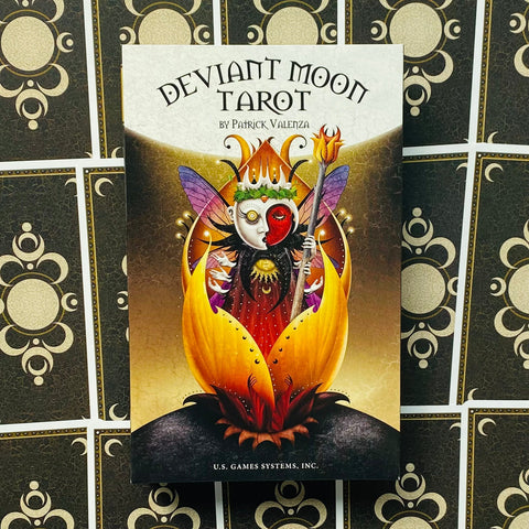 Deviant Moon tarot kortų rinkinys su spalvingu karalienės-mėnulio viršeliu ir ryškia geltona žiedo iliustracija