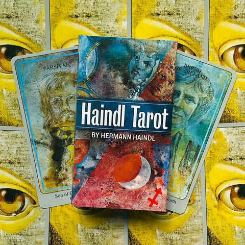 Haindl tarot dėžutė ir dvi kortos; Hermann Haindl dizainas, mėlyno‑raudonas viršelis ant geltonų akių fono