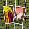Tarot kortos Rider‑Waite stiliaus, atvertos III ir IV taurės priekinės pusės, matomas keltiškas juodai‑žalias nugarėlių raštas