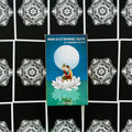 Sun and Moon tarot kortos dėžutė (Vanessa Decort) centre ant ornamentuotos juodos kortų išklotinės, mėlynas viršus su lotoso motyvu