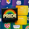 Pride rinkinys juodoje dėžutėje su ryškia vaivorykšte, geltonomis ir žaliomis įkvėpimo kortelėmis ir lipdukais, artimas viršaus planas