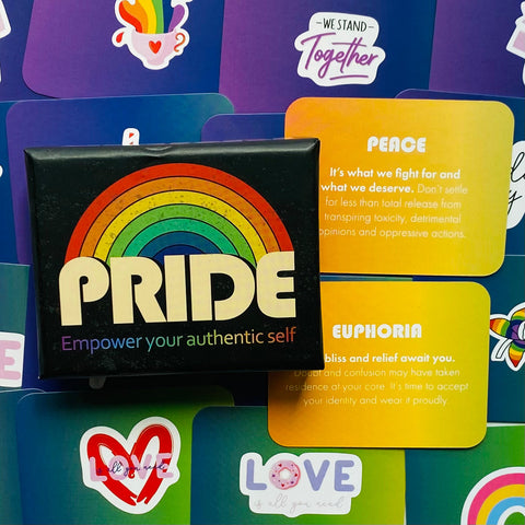 Pride rinkinys juodoje dėžutėje su ryškia vaivorykšte, geltonomis ir žaliomis įkvėpimo kortelėmis ir lipdukais, artimas viršaus planas