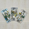 Tarot kortos retro dizaino rinkinio trys kortos ant raštuoto fono, išdėstytos pasvirai — dvi apverstos, viena stačia