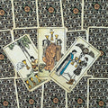 tarot kortos Rider–Waite stiliaus, sendintos smėlio spalvos priekinės kortos ir ornamentuotos nugarėlės, trijų taurų išdėstymas skaitymui