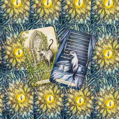 tarot kortos su kačių iliustracijomis, mėlyno‑žalio nugarėlės raštu ir dviem atverstomis kortomis (Devyni kardai, Dešimt kardų)