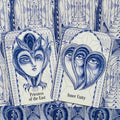 Tarot kortos su mėlynomis pieštinėmis iliustracijomis, arti matomos dvi kortos (Priestess of the East, Inner Unity) ir detalus raštas