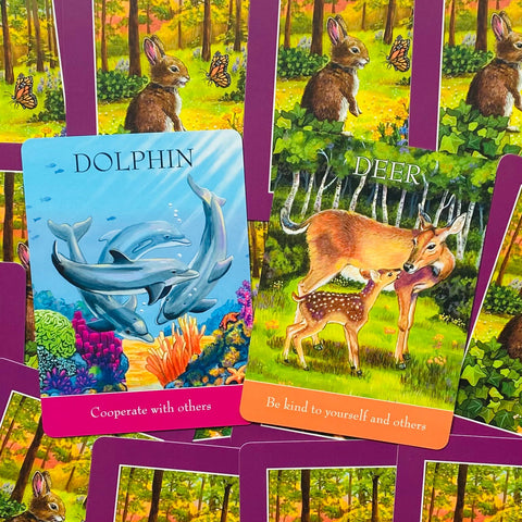 Orakulų kortos atvertos dviem – „Dolphin“ ir „Deer“ su ryškiais mėlynais ir žaliais iliustracijomis, purpurinė nugarėlė ir skirtingi gyvūnų variantai prekių galerijoje