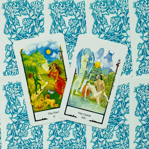 Tarot kortos su atvirais priekiais: The Fool ir The Guide kortos ant mėlyno gėlių nugarėlio, skirtos komplektui parodyti
