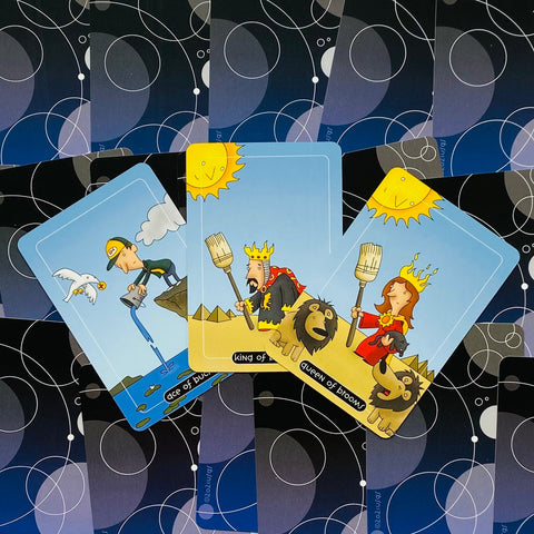 tarot kortos su tamsiai mėlynomis nugarėlėmis, trys spalvingos iliustruotos kortos (karalius, karalienė, tūzas) iš viršaus