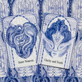 Orakulų kortos atverstos dviem: mėlynos ornamentinės kortos su veidų motyvais, matomos „Inner Nemesis“ ir „Clarity and Truth“ kortos, artimas planas