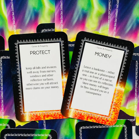 orakulų kortos su auroros spalvų fone, dvi atvertos kortos „Protect“ ir „Money“ su tekstiniais patarimais finansinei apsaugai