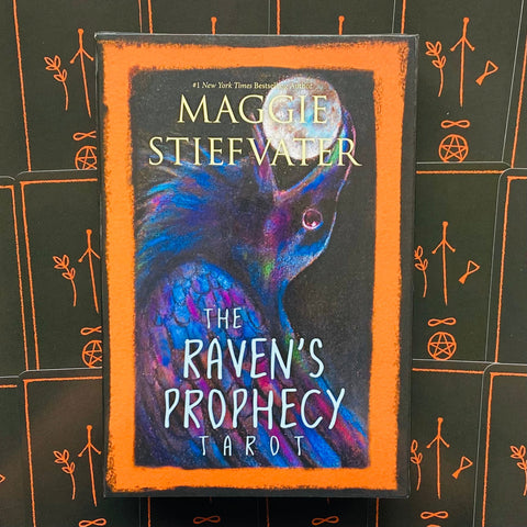 Tarot kortos The Raven's Prophecy Maggie Stiefvater, oranžiniu rėmeliu ir tamsiu varno iliustracijos dėžutės priekinis vaizdas