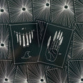 Tarot kortos juodame variante su baltomis iliustracijomis — dvi atverstos kortos (delno su plunksnomis ir vabzdžių gaudyklės motyvai) ant spinduliuotės raštuoto nugarėlių fono