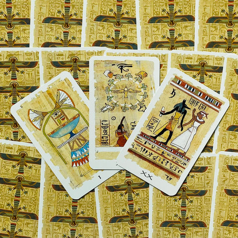 Tarot kortos su egiptietiškais piešiniais, trys atverstos kortos ant raštuoto aukso fono, skirtos skaitymams