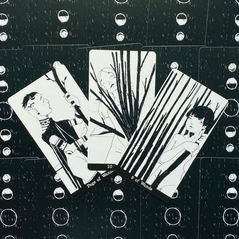 Tarot kortos juodai baltas iliustruotas rinkinys, trijų kortų flatlay (Page, 10 ir 9 of Wands), detalus priartinimas