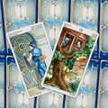 Tarot kortos su mėlynomis nugarėlėmis ir auksiniais raktais, dvi atverstos — jaunuolis prie durų ir medyje namelis, Pentaklių variantai
