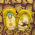 Tarot kortos su auksiniais rėmais — The Moon (XVIII) ir The Star (XVII) ant bordo nugarėlių, artimas kampas